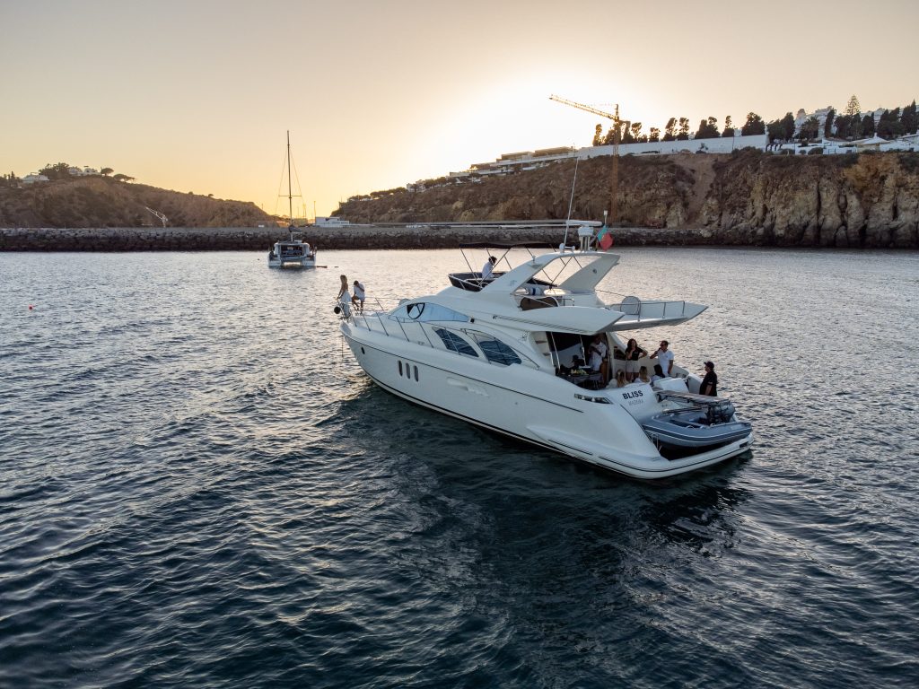 Luxury yacht experience Algarve during sunset along the coastline